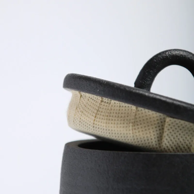 Detail of lid of dark grey ceramic storage jar