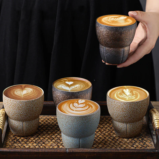 GWoman hands with four japanese ceramic drinking cups with cappuccino coffee and wooden tray