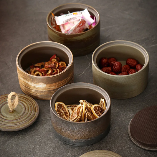 Set of four japandi ceramic storage jars on dark neutral background