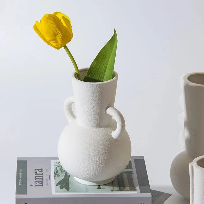 White textured vase with two handles, with yellow flower