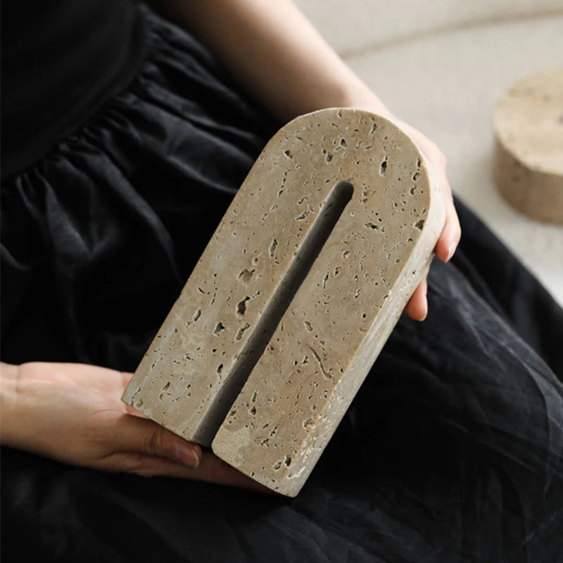 Woman holding handcrafted, arch shaped travertine book end on her lap