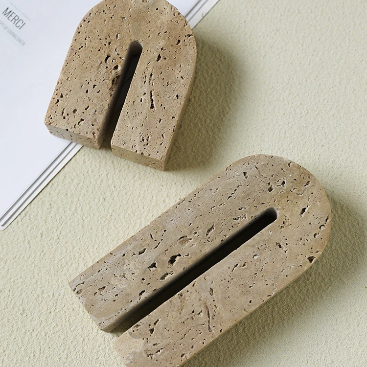 View of handcrafted, arch shaped travertine book end on neutral background