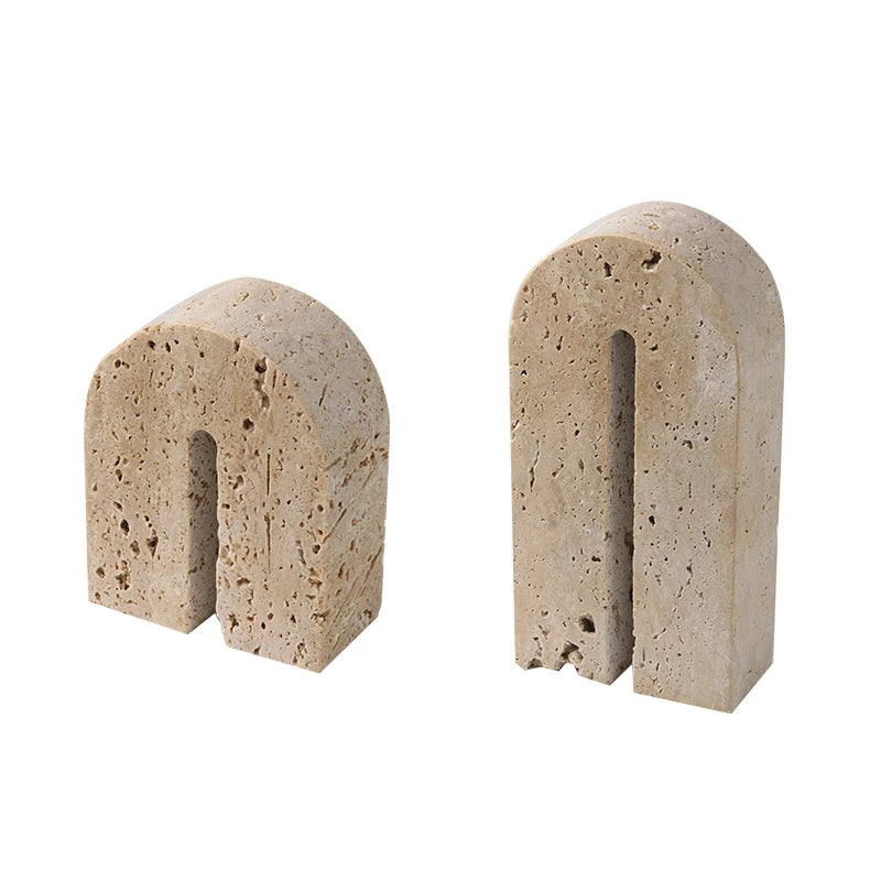 Handcrafted, arch shaped travertine book end set on white background