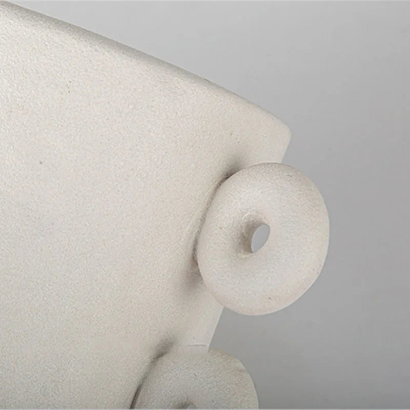 Close up of round details of white textured ceramic planter on white background
