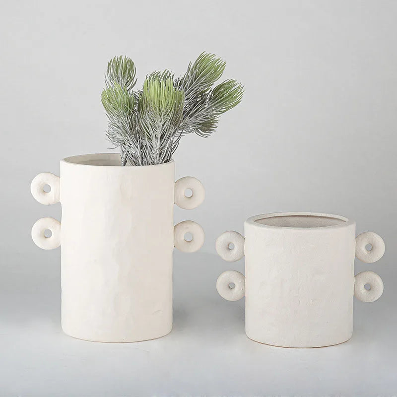 Set of two white textured ceramic planter with round details on sides, on white background