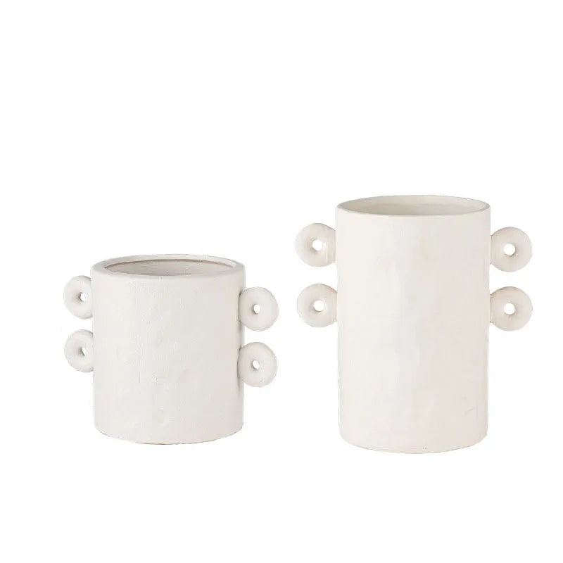 Set of two white textured ceramic planter with round details on sides, on white background
