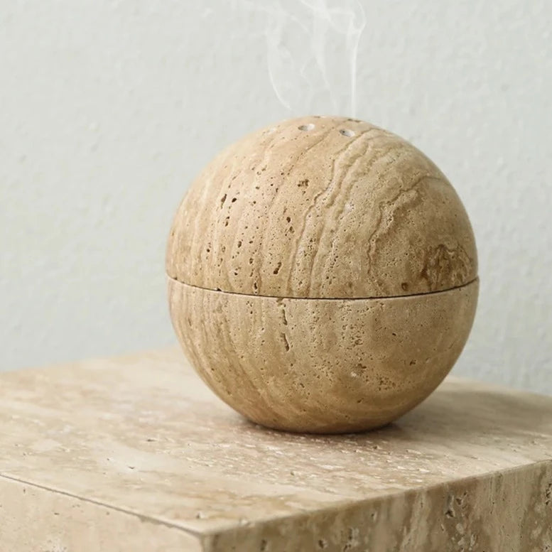 Spheric travertine stone incense burner on neutral background