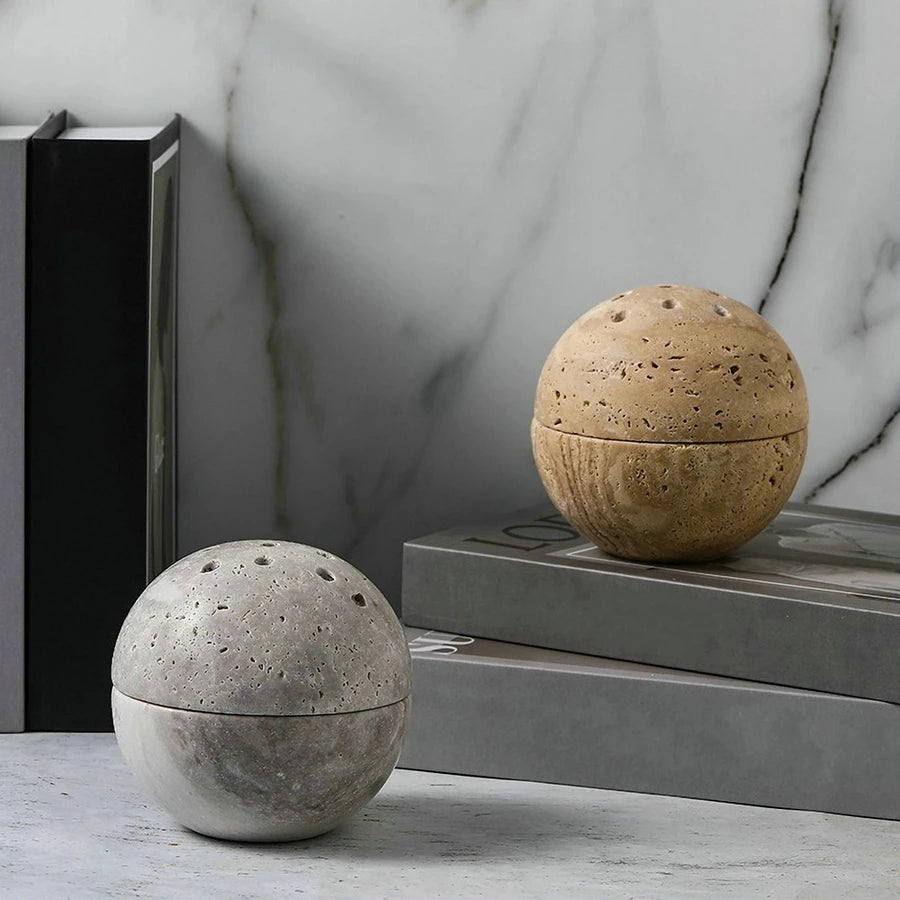 Set of two spheric travertine stone incense burner on neutral background