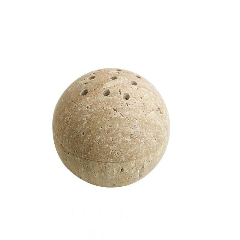 Spheric, beige travertine stone incense burner on white background
