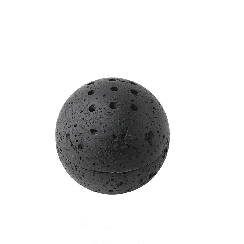 Spheric, black travertine stone incense burner on white background