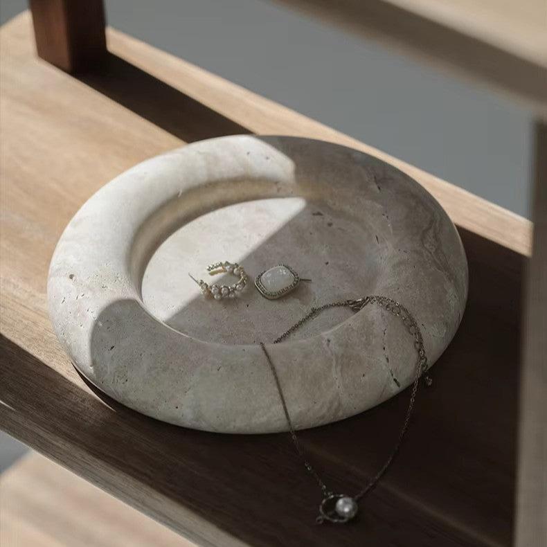 Round marble tray on wooden bookcase