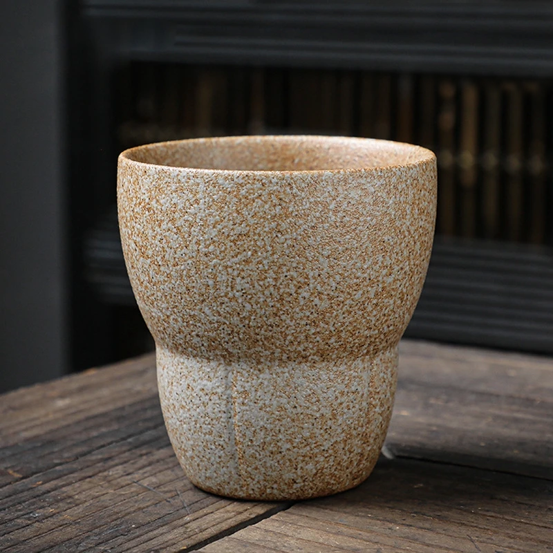 Beige textured ceramic drinking cup on wooden table