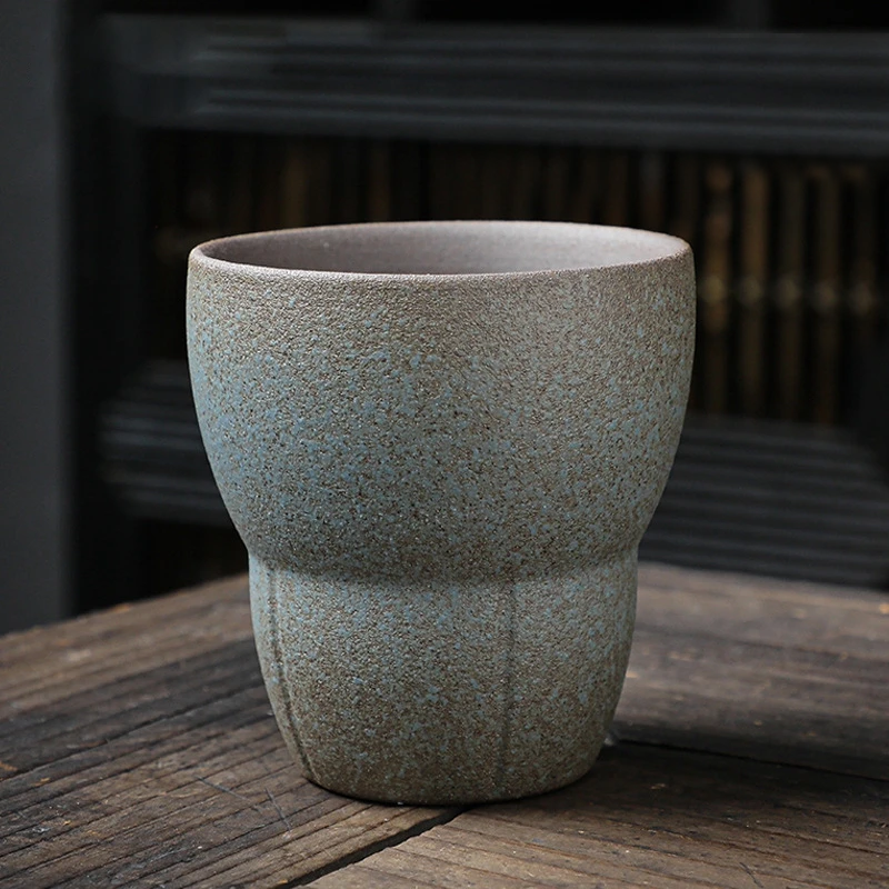 Light blue and beige textured japanese ceramic drinking cup on wooden table
