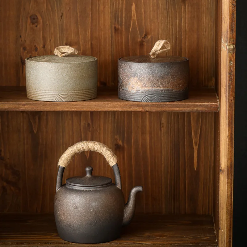 Ceramic lidded storage containers and teapot on wooden bookshelf