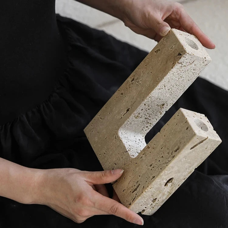 Woman’s hands holding handcrafted travertine candle holder