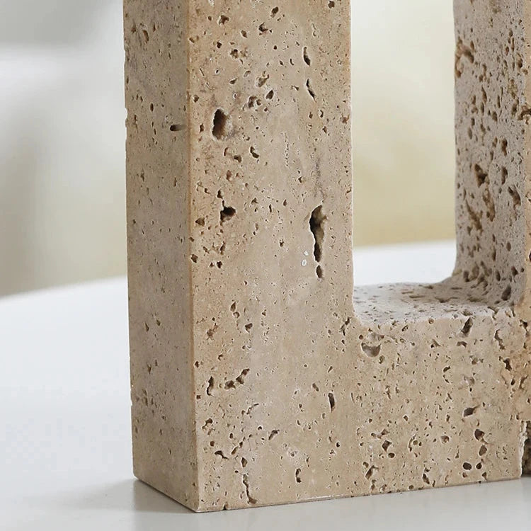 Detail of handcrafted travertine candle holder on neutral background