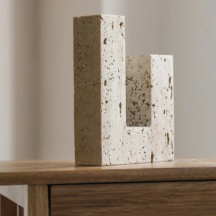 Handcrafted travertine candle holder on wood table and neutral background