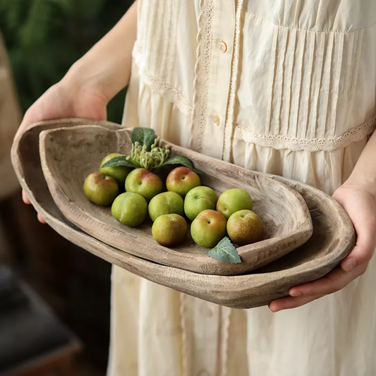 Woman's hands holding Japandi wooden trays with colored fruit