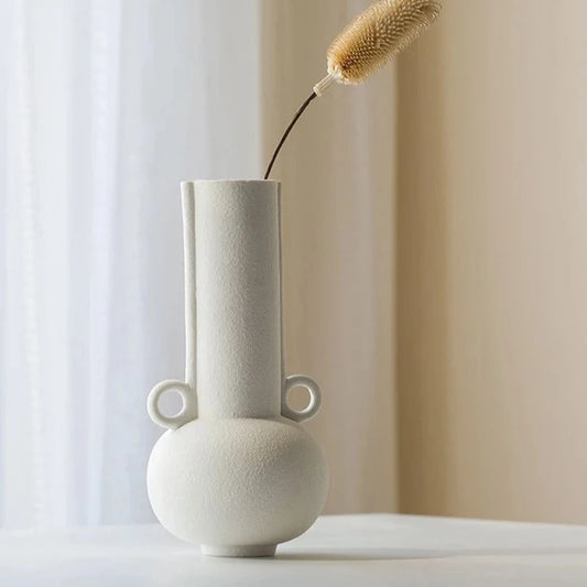 White textured vase with long neck on neutral room background
