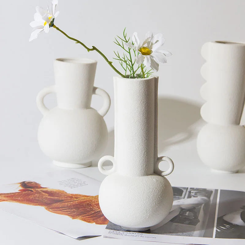 Three white textured vases on white room background and flower