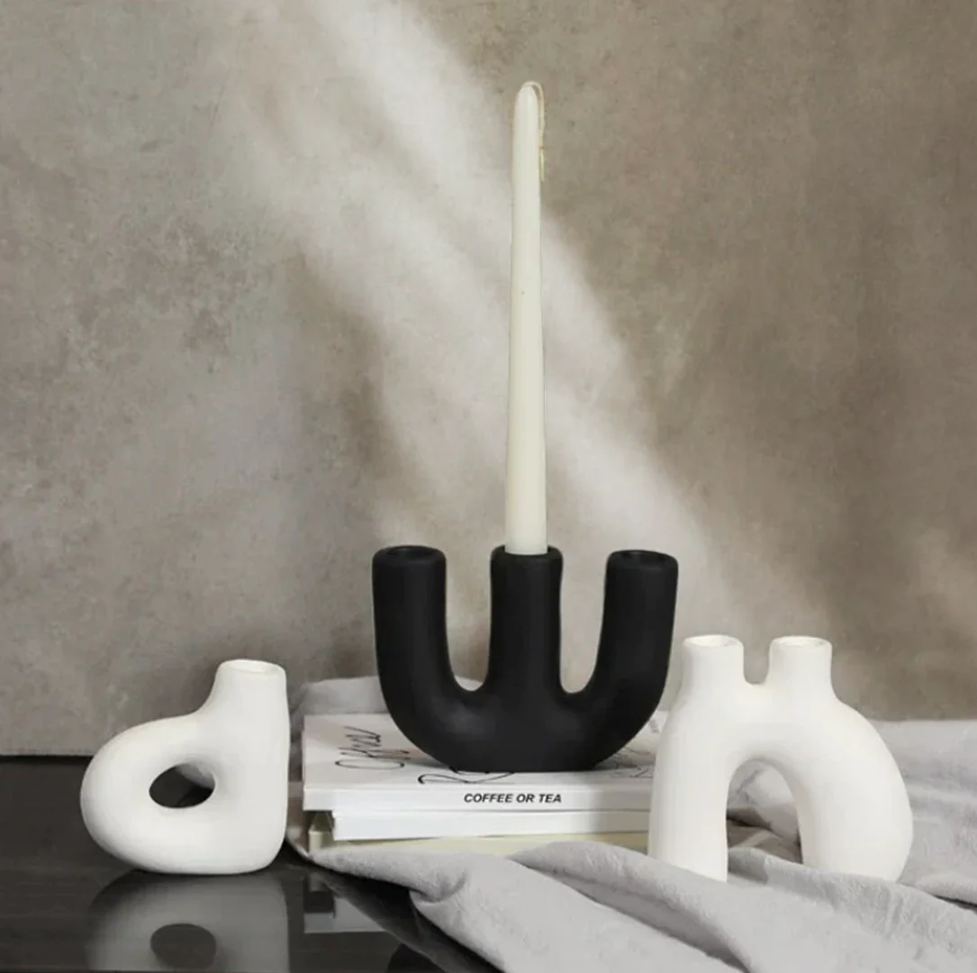 Three organic shaped ceramic candle holders on neutral background