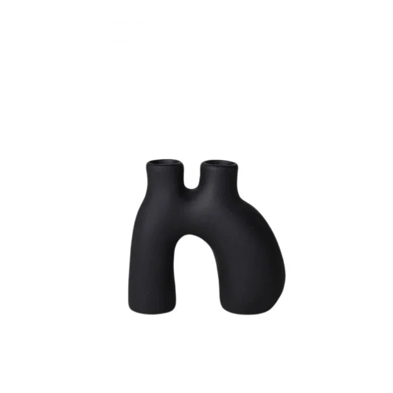 Organic shaped black ceramic candle holder on white background