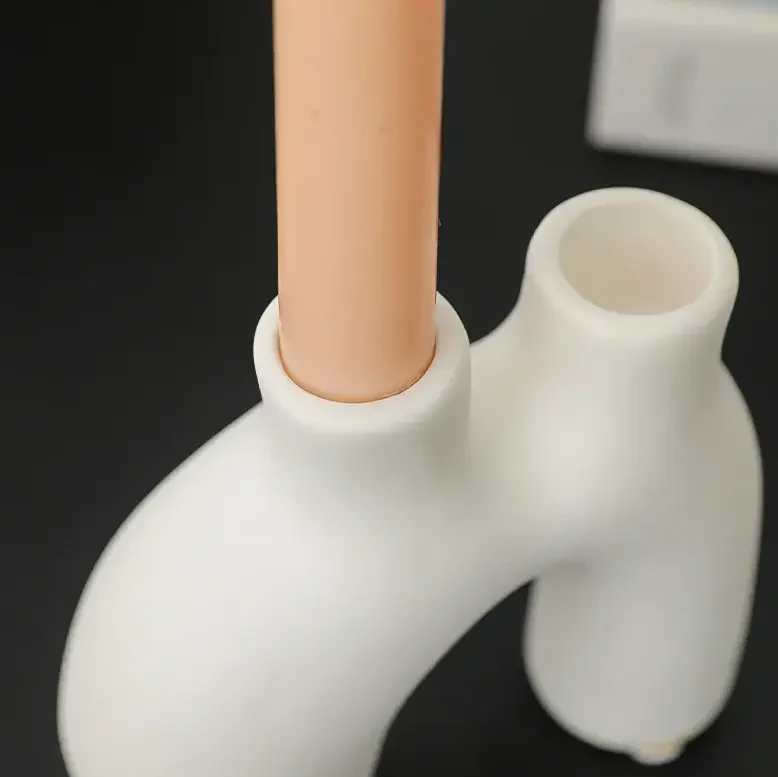 Detail of white organic shaped ceramic candle holder on dark background