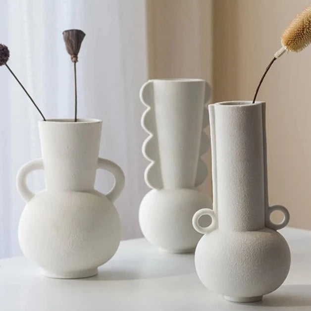 Three white textured vases on neutral room background