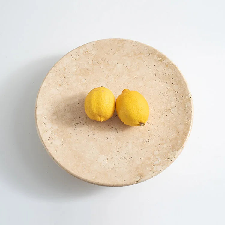 Top view of wo lemons on travertine round tray on neutral background