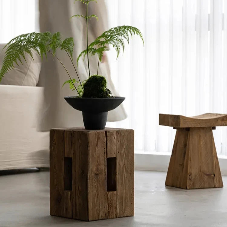 Handcrafted rectangular wooden side table with black vase and plant in japandi living room