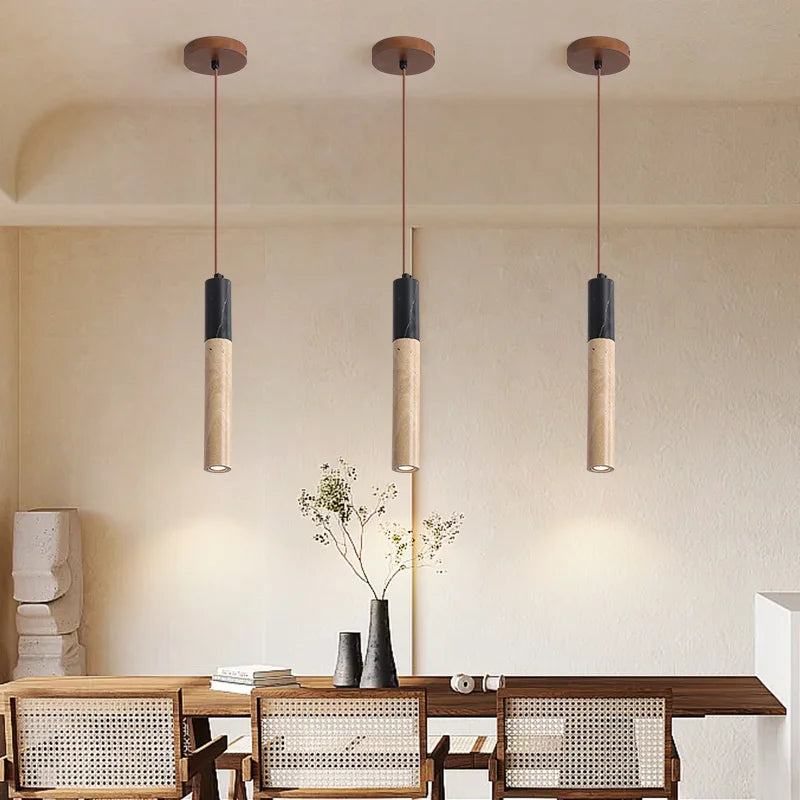 Three travertine japandi pendant lights hanging over wooden japandi table