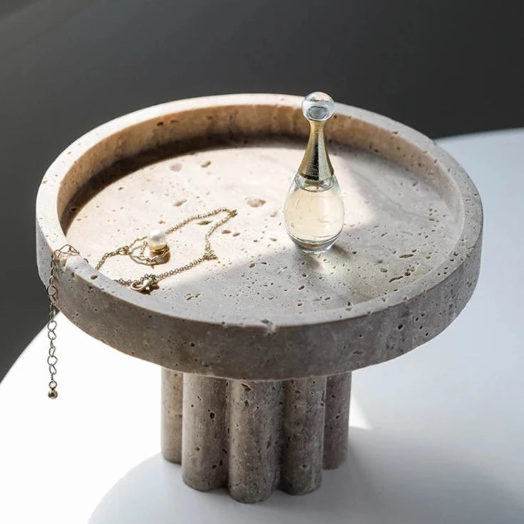 Top view of round travertine tray with scalloped stand detail in neutral room