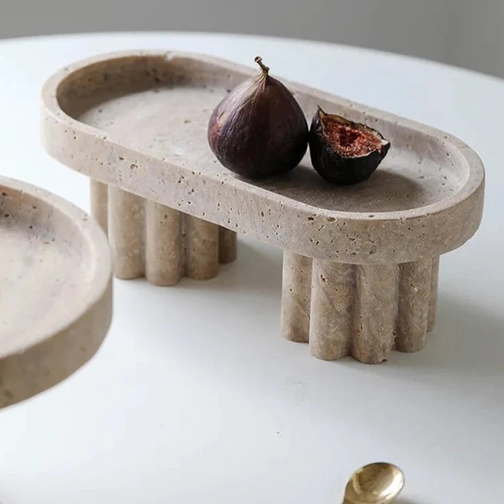 Oval travertine tray with two scalloped feet in neutral room