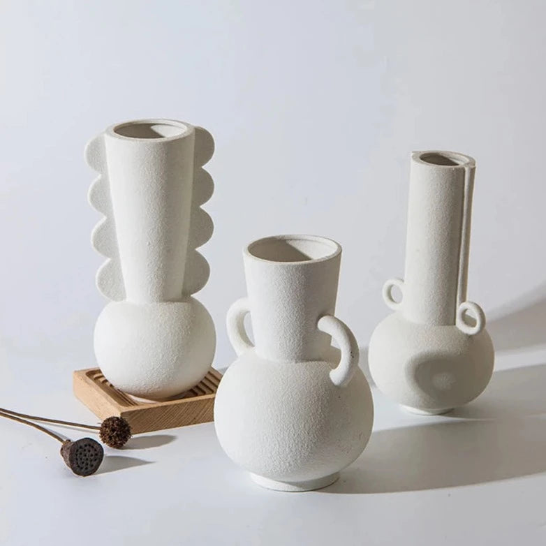 Three white textured vases on white room background