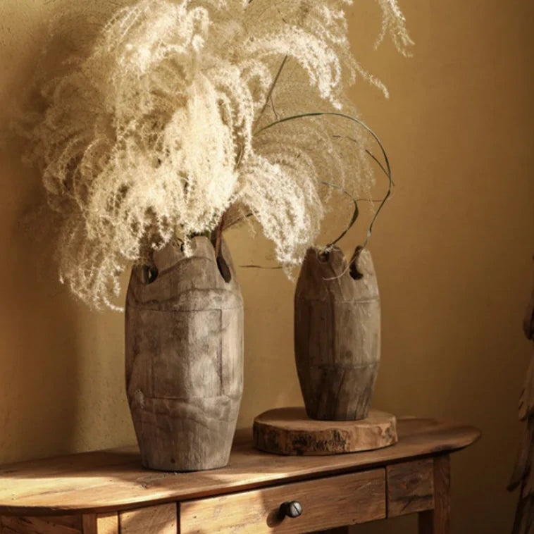 Set of two handcrafted japandi wooden vases with pampa plant, on wood cabinet and warm background