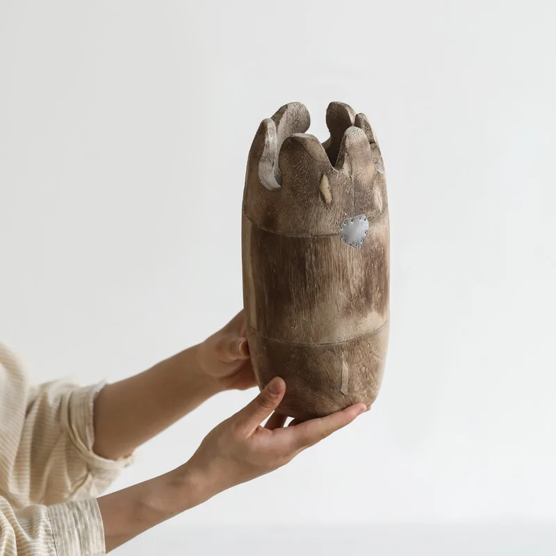 Hands holding handcrafted japandi wooden vase and white background