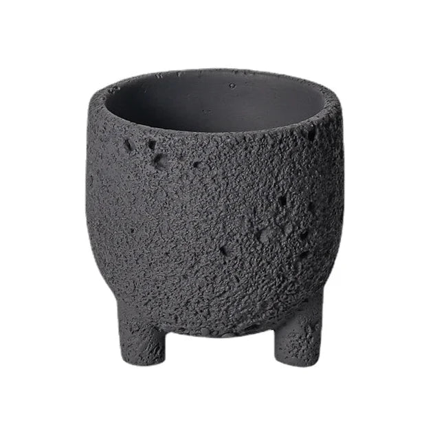 Black textured planter with feet on white background