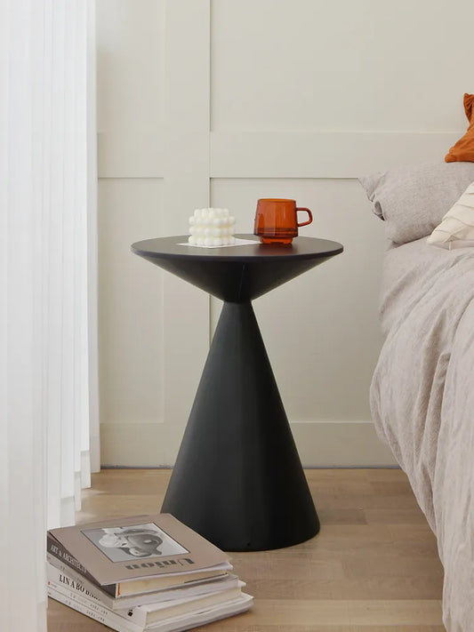 Sleek black lightweight metal side table in minimalist bedroom