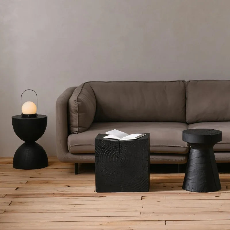 Three black wooden side table and a brown couch, neutral colors