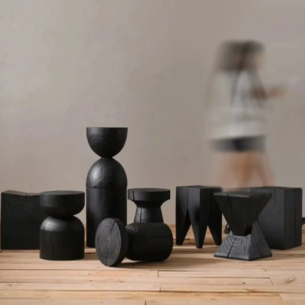 Frontal view of many wooden tables in different shapes, with black finish
